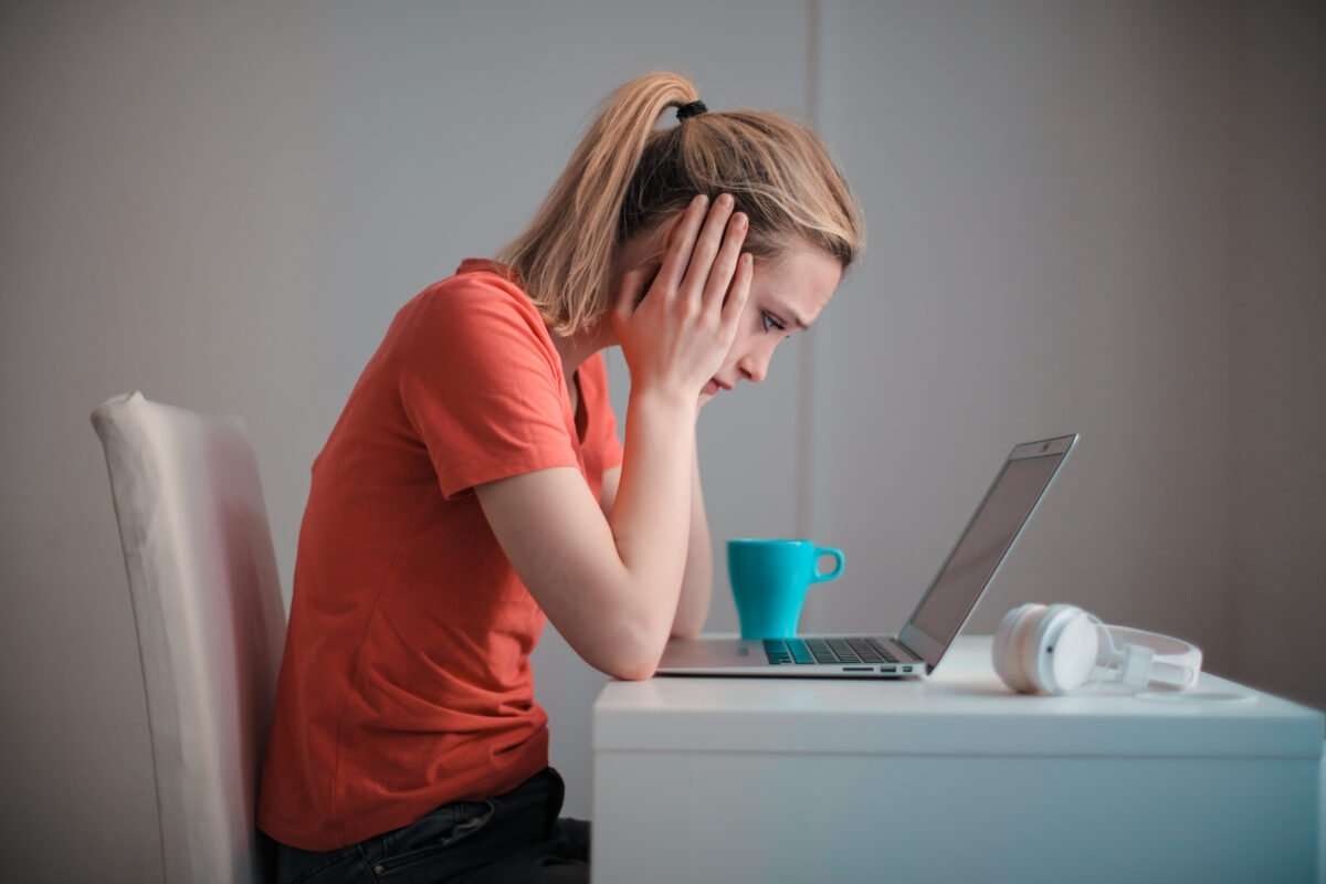 Woman in front of a laptop frustrated by her workflow management